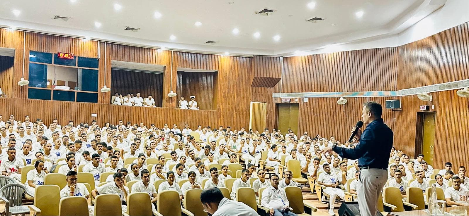 A speaker addressing a large life-support training audience in an auditorium