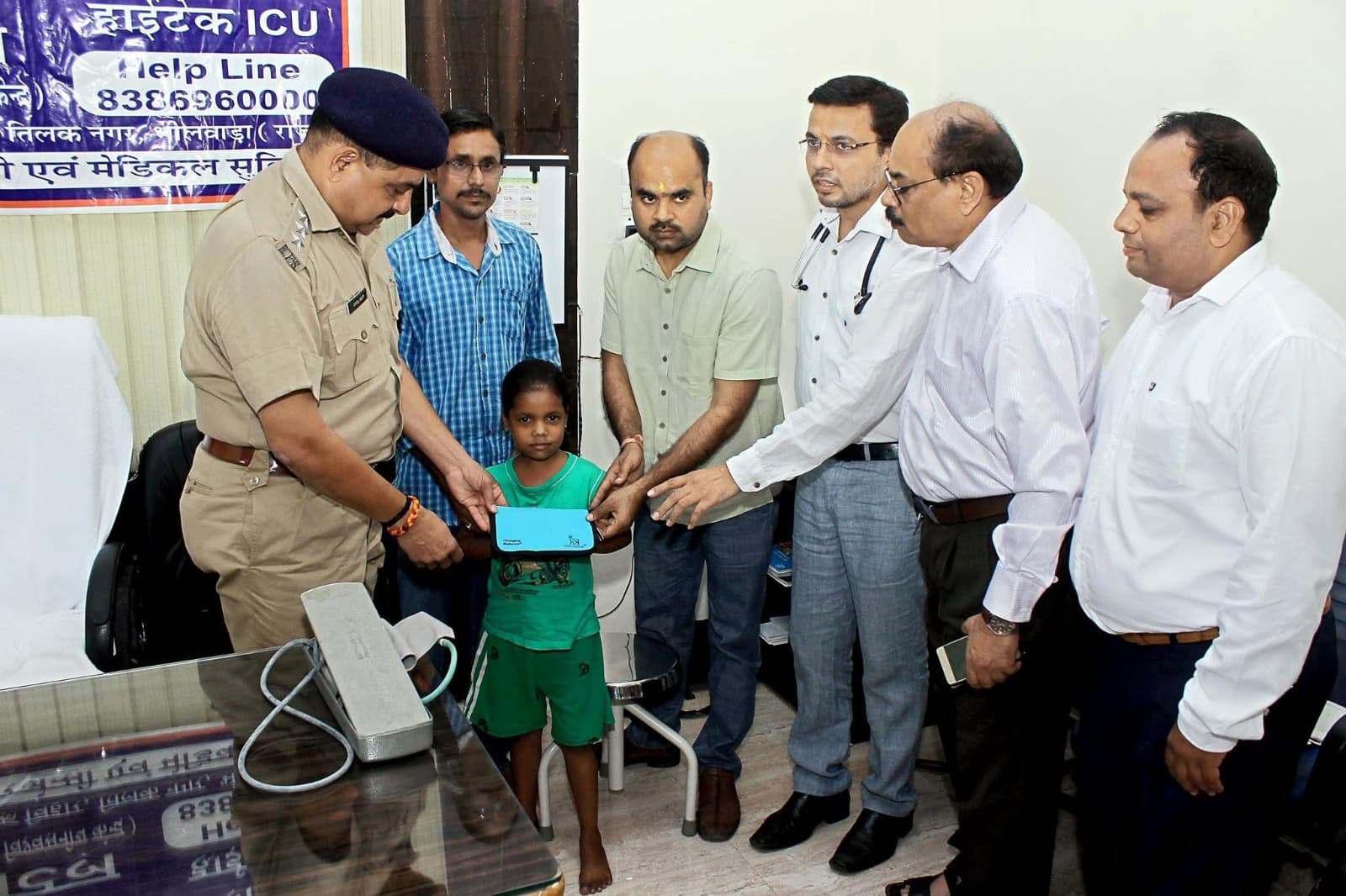 Community outreach with a child receiving support, with a doctor and officials present